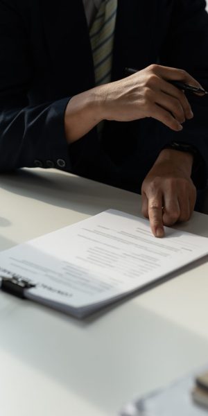 client customer signing contract and discussing business with legal consultants, notary or justice lawyer with laptop computer and wooden judge gavel on desk in courtroom office, legal service concept.